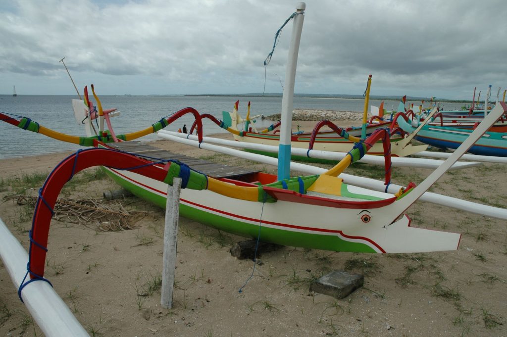Jukung outrigger boats pulled up on the sand at Sanur beach