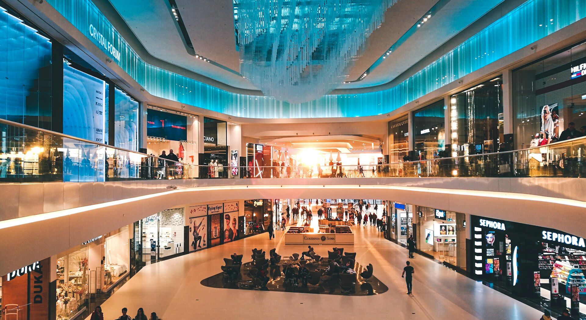 Multi-level luxury shopping atrium lined with brand boutiques