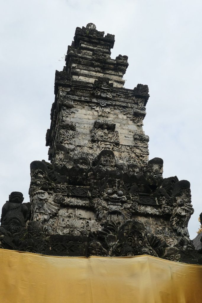 The weathered stone main shrine of Pura Sakenan rising against the sky